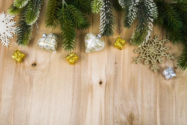 Flocons de neige argentés et branches de sapin sur une table en bois. Noël — Photo