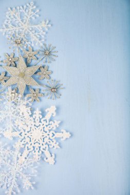 Mavi ahşap arka plan üzerinde gümüş dekoratif kar taneleri. İsa