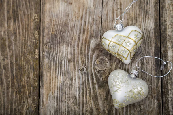 Δύο καρδιές από ασήμι σε ένα ξύλινο υπόβαθρο. Χριστουγεννιάτικο διακοσμητικό o — Φωτογραφία Αρχείου