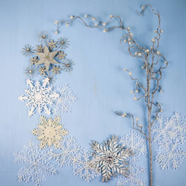 Flocos de neve decorativos de prata e galho em um backgro de madeira azul — Fotografia de Stock