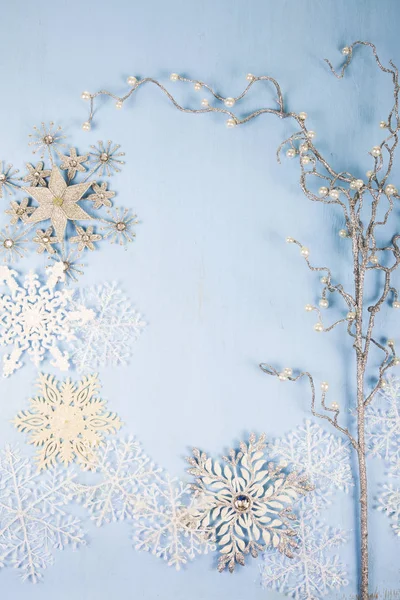 Zilveren decoratieve sneeuwvlokken en branch op een blauwe houten backgro — Stockfoto