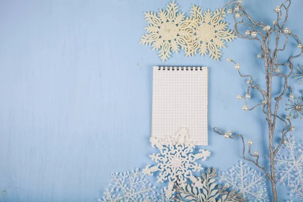 银装饰雪花和蓝色的木制 bac 上一个笔记本 — 图库照片