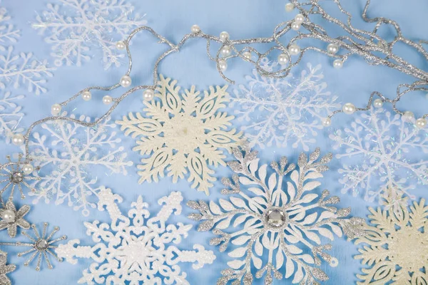 Mavi ahşap arka plan üzerinde gümüş dekoratif kar taneleri. İsa — Stok fotoğraf