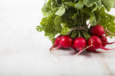 Olgun kırmızı turp ile bir ahşap masa yakın çekim yaprak. Taze ve