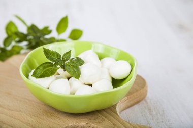 Mozzarella ahşap bir masa üzerinde yeşil bir tabak içinde. Lezzetli taze c