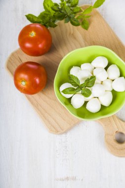 Mozzarella ahşap bir masa üzerinde yeşil bir tabak içinde. Mozzarella topları 