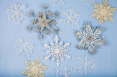 Mavi ahşap arka plan üzerinde gümüş dekoratif kar taneleri. İsa