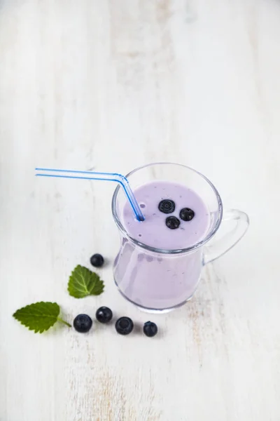 Smoothie oder Joghurt mit Blaubeeren auf einem Holztisch. lecker — Stockfoto