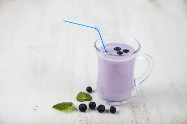 Smoothie o yogur con arándanos en una mesa de madera. Delicioso. —  Fotos de Stock