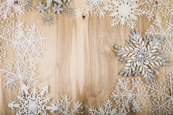 Flocos de neve de prata em uma mesa de madeira. Decorações de Natal perto — Fotografia de Stock