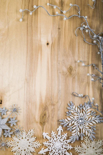 Silberne Schneeflocken und dekorativer Zweig auf einem Holztisch. Weihnachten — Stockfoto