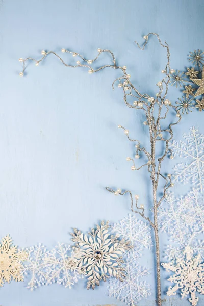 Copos de nieve decorativos de plata y rama en un backgro de madera azul — Foto de Stock