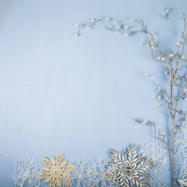 Flocons de neige décoratifs argentés et branche sur un fond en bois bleu — Photo