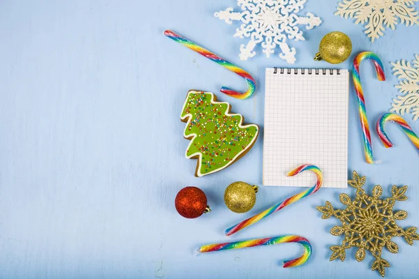 Notebook, cukorka és mézeskalács fa kék háttérrel. C — Stock Fotó