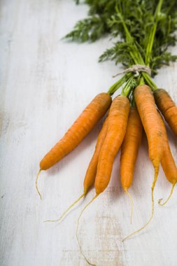 Olgun kırmızı havuç ile bir ahşap masa yakın çekim yapraklarda. Taze v