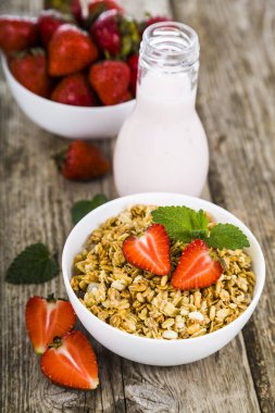 Granola ahşap bir masa üzerinde çilek ile. Sağlıklı beslenme.
