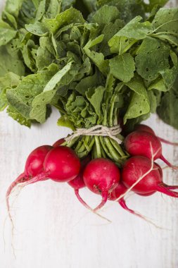 Olgun kırmızı turp ile bir ahşap masa yakın çekim yaprak. Taze ve