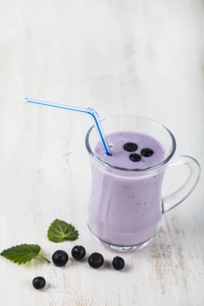 Smoothie oder Joghurt mit Blaubeeren auf einem Holztisch. lecker — Stockfoto