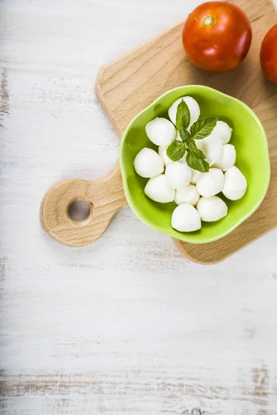 Mozzarella v zelené desky na dřevěný stůl. Kuličky mozzarelly — Stock fotografie