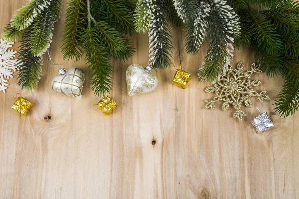Copos de nieve de plata y ramas de abeto en una mesa de madera. Navidad — Foto de Stock