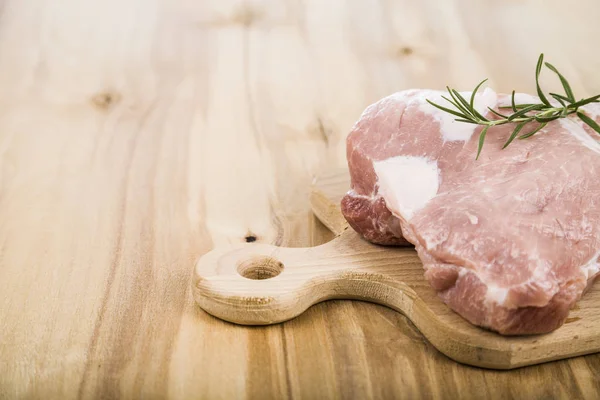 迷迭香在桌子上木板上的生猪肉。烹饪的 f — 图库照片