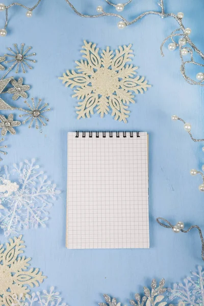 银装饰雪花和蓝色的木制 bac 上一个笔记本 — 图库照片