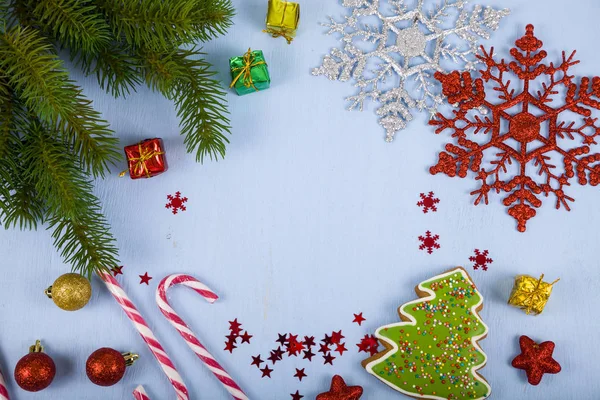 Flocons de neige, bonbons, cadeaux et branches de sapin sur une table en bois. Ch. — Photo