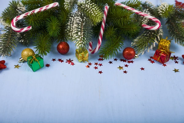 Copos de nieve, caramelos, regalos y ramas de abeto en una mesa de madera. Ch — Foto de Stock