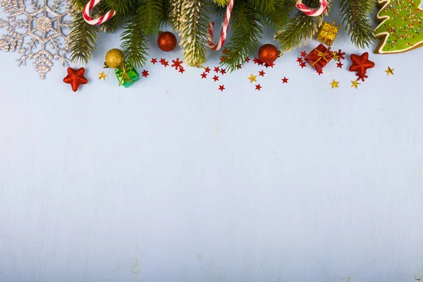 Flocos de neve, balas, presentes e ramos de abeto em uma mesa de madeira. Ch... — Fotografia de Stock