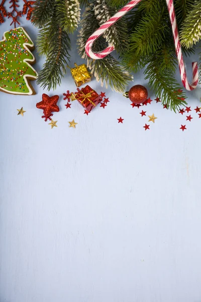 Flocons de neige, bonbons, cadeaux et branches de sapin sur une table en bois. Ch. — Photo