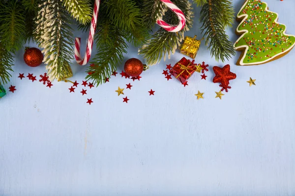 Schneeflocken, Bonbons, Geschenke und Tannenzweige auf einem Holztisch. ch — Stockfoto