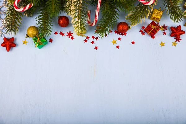 Schneeflocken, Bonbons, Geschenke und Tannenzweige auf einem Holztisch. ch — Stockfoto