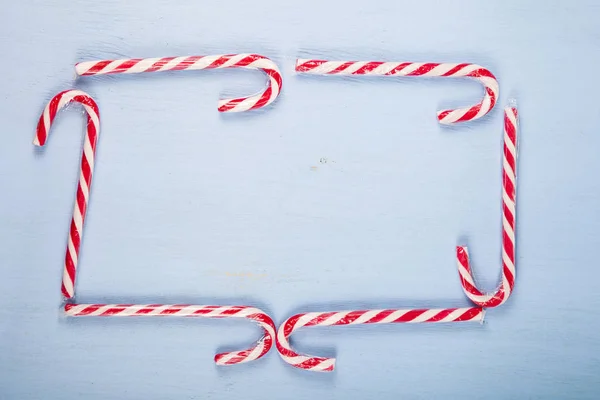 Marco de bastones de caramelo sobre fondo de madera. Dulces de Navidad a — Foto de Stock