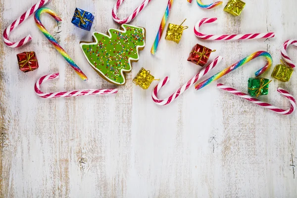 Gingerbread and candy canes on a  wooden background. Christmas s — Stock Photo, Image