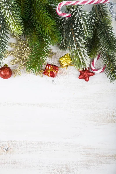 Ozdoby świąteczne, prezenty i gałęzie jodły na drewnianym stole. — Zdjęcie stockowe