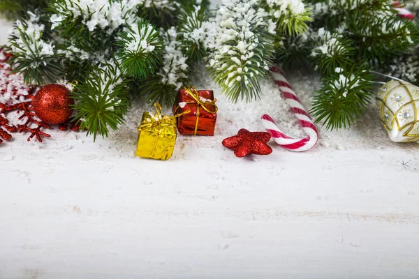 Vánoční ozdoby, dárky a větve jedle na dřevěný stůl. — Stock fotografie