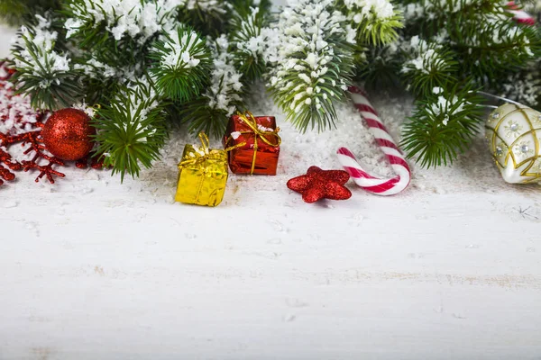 Juldekorationer, gåvor och fir grenar på ett träbord. — Stockfoto