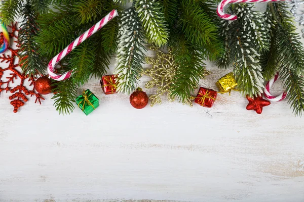 Χριστουγεννιάτικα στολίδια, τα δώρα και κλαδιά έλατου σε ένα ξύλινο τραπέζι. — Φωτογραφία Αρχείου