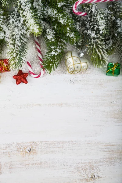Ozdoby świąteczne, prezenty i gałęzie jodły na drewnianym stole. — Zdjęcie stockowe