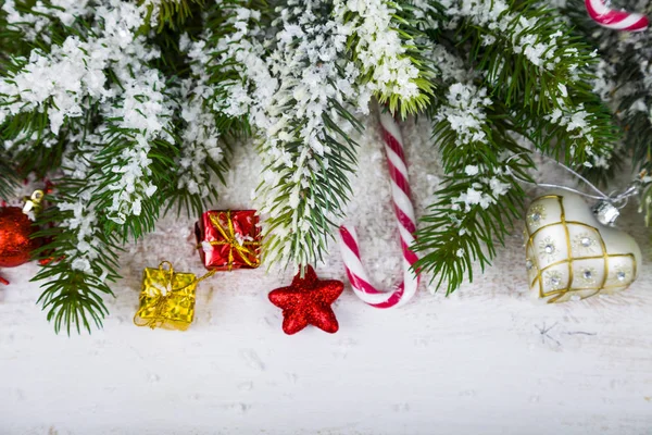 Karácsonyi díszek, ajándékok és egy fából készült asztal fenyő ágak. — Stock Fotó