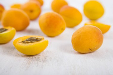 Ahşap masa lambası yakın çekim üzerinde olgun sarı kayısı.