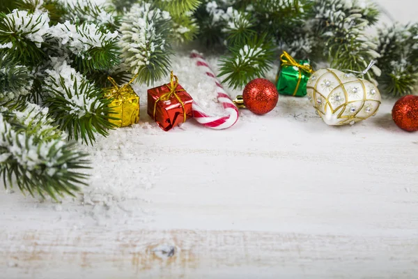 Karácsonyi díszek, ajándékok és a fenyő ágak a hó a w — Stock Fotó