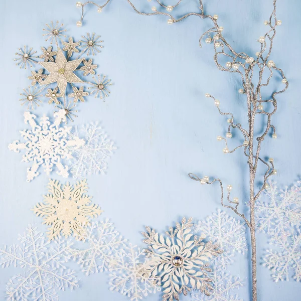 Fiocchi di neve decorativi d'argento e ramo su un backgro di legno blu — Foto Stock