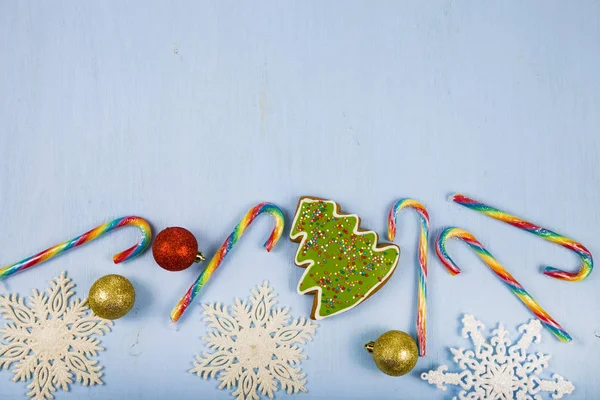 Pepparkakor och godis käppar på en blå trä bakgrund. Julstämning — Stockfoto