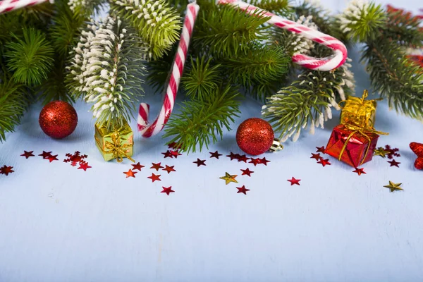 Sneeuwvlokken, snoepjes, giften en Spar takken op een houten tafel. CH — Stockfoto