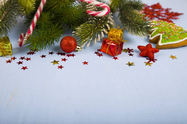 Snöflingor, godis, presenter och fir grenar på ett träbord. CH — Stockfoto