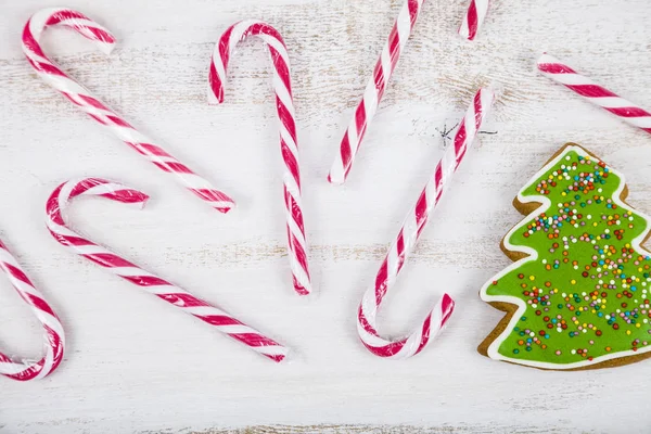 Bastoncini di pan di zenzero e caramelle su sfondo di legno. Natale s — Foto Stock