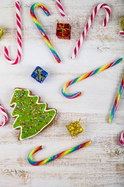 Bastoncini di pan di zenzero e caramelle su sfondo di legno. Natale s — Foto Stock