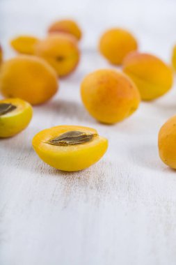 Ahşap masa lambası yakın çekim üzerinde olgun sarı kayısı.