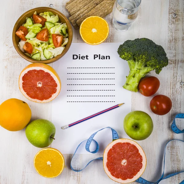 Voedsel en vel papier met een dieetplan op een houten tafel. CON — Stockfoto